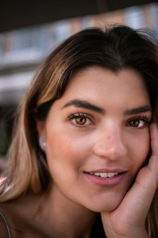 a smiling woman with her hand on her face