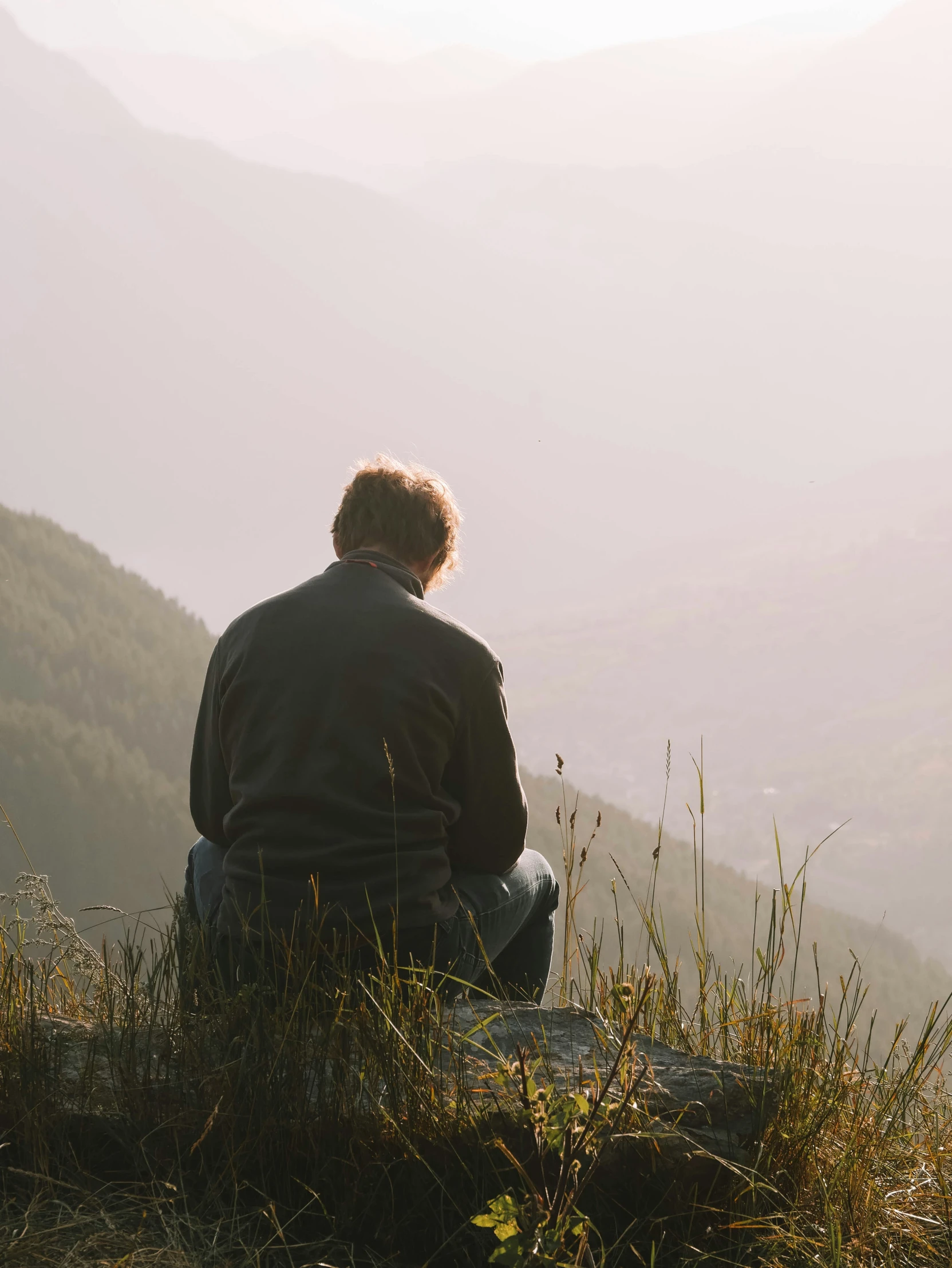 a man sits in the shade on top of a mountain