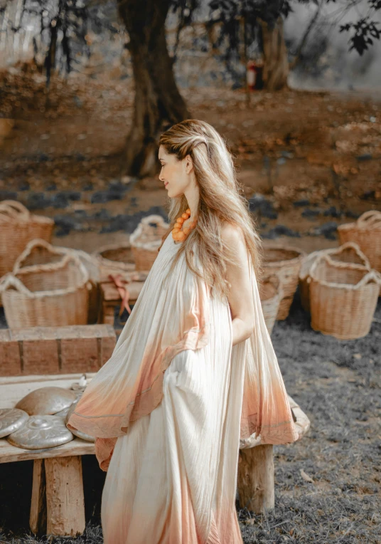 a woman in an orange dress stands near baskets of food