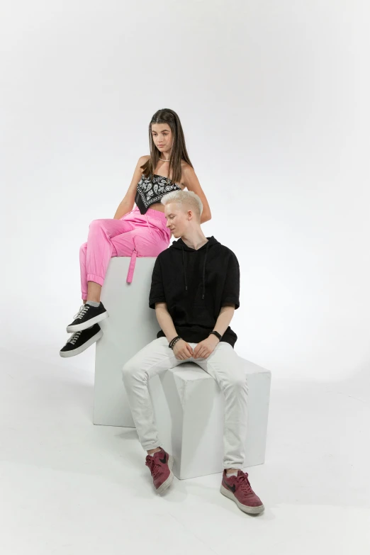 there is a young man and woman sitting together on a paper block