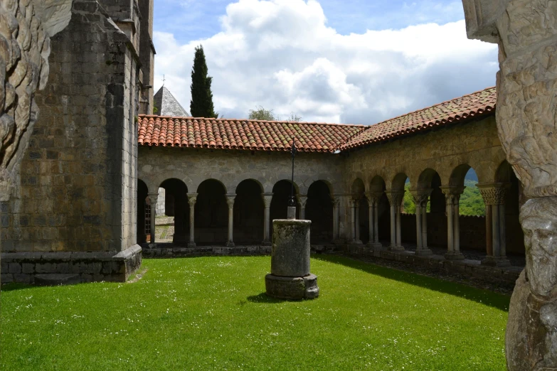 a stone building with a green lawn and grass