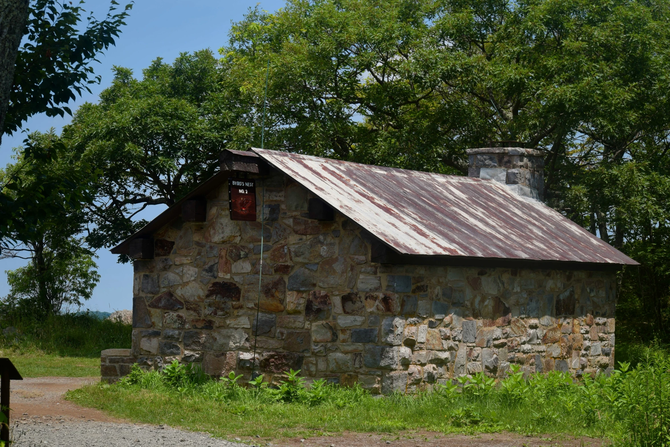 an old stone building stands near the dirt path