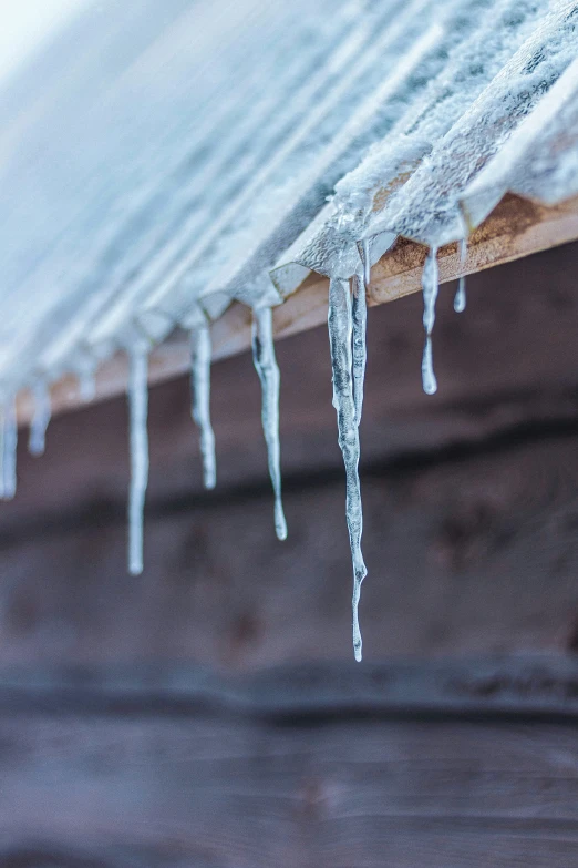 icicles hanging off the side of a brown roof