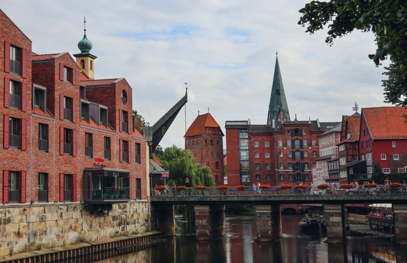 an old bridge has been built in front of the brick buildings