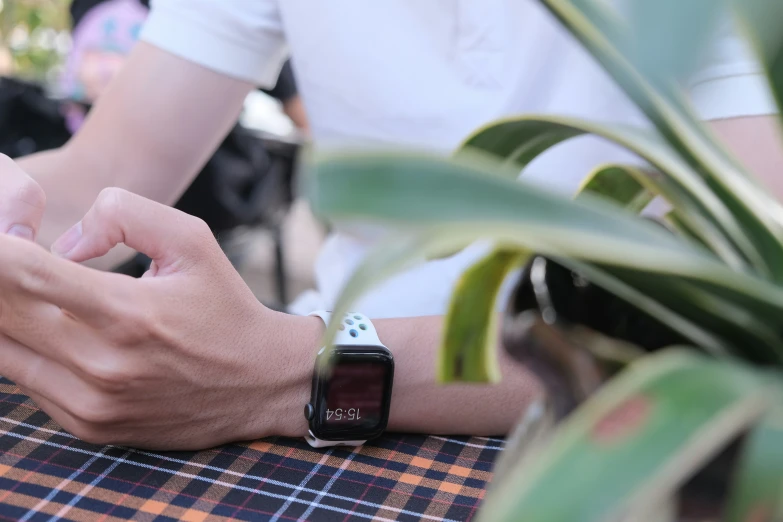 a person sitting at a table using their smart phone