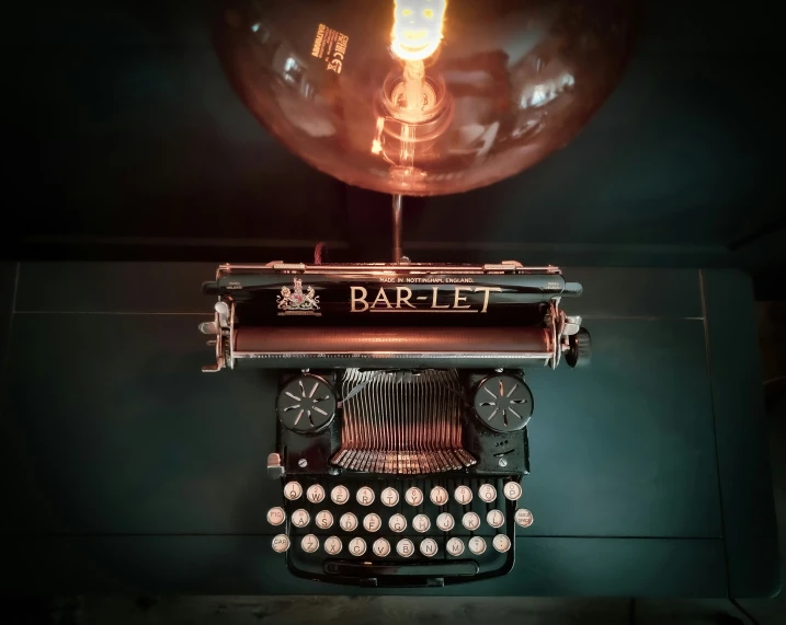 the light bulb above the typewriter is dim and dark