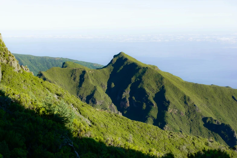 a grassy slope in the middle of some mountains