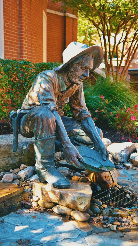 a bronze statue sits next to a fire pit