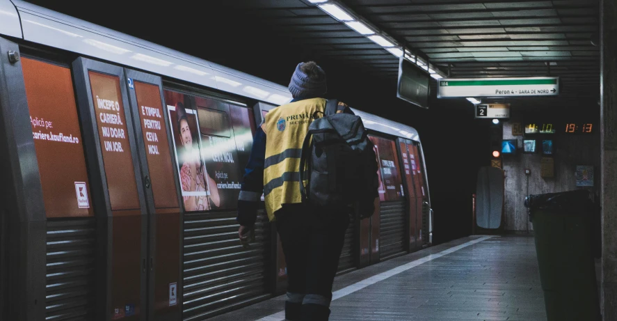 a person walking towards a subway train in a subway