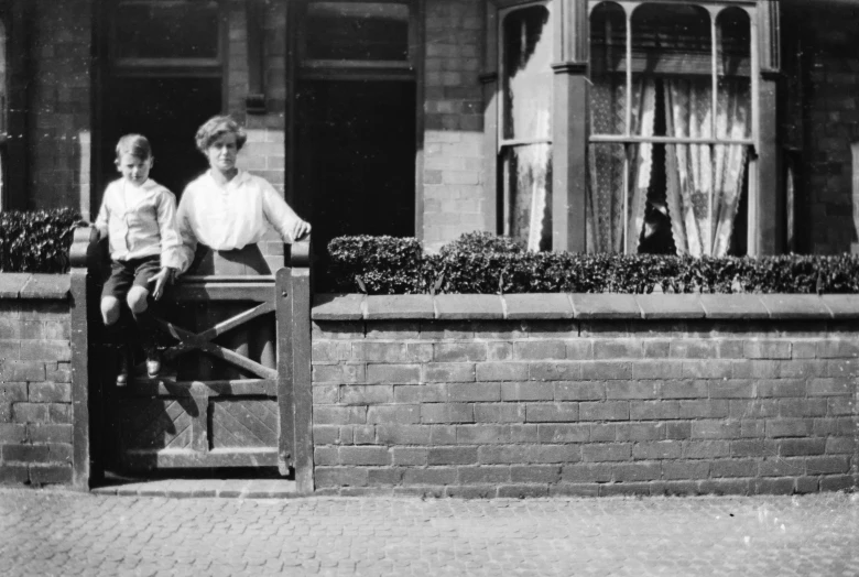 two people are posing outside of a house