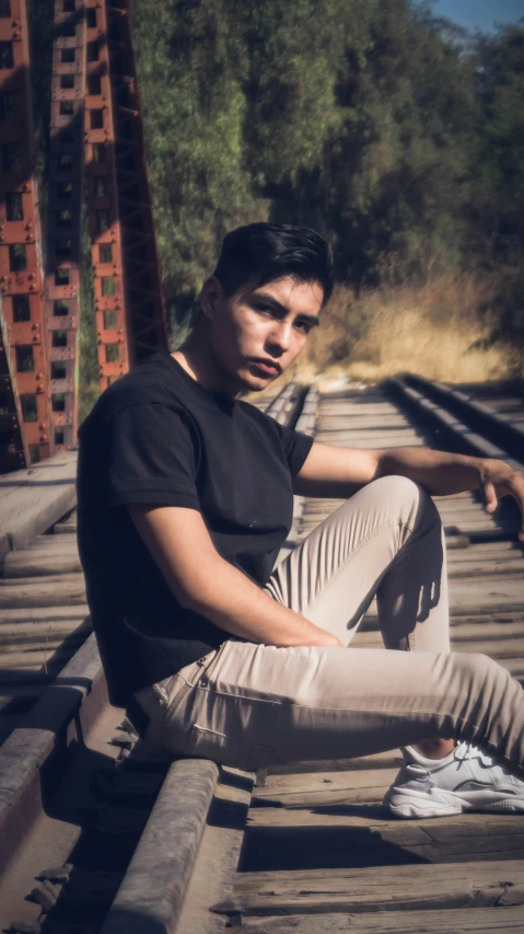 a young man sitting on top of train tracks