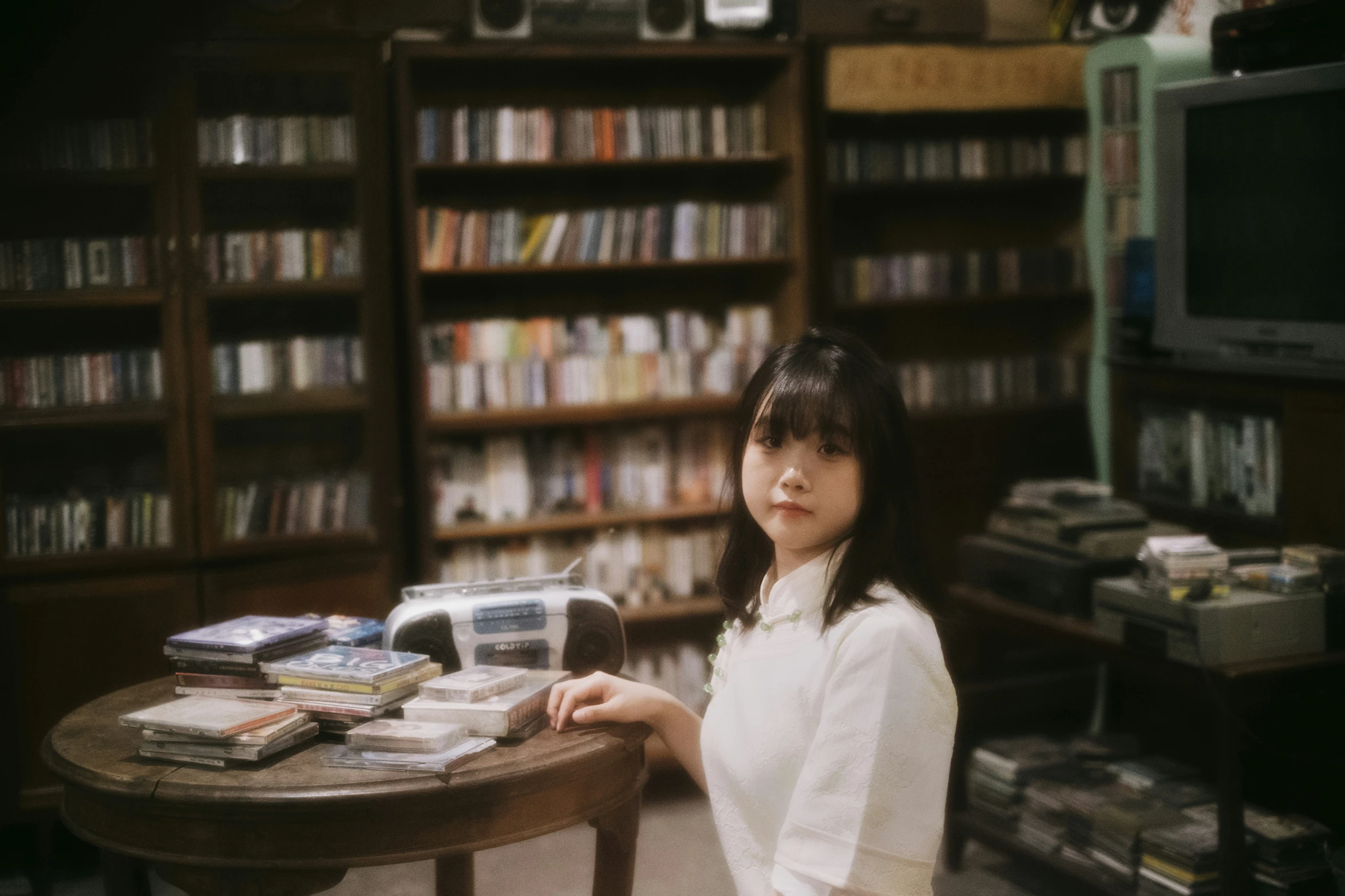 a young woman stands at a table in the liry