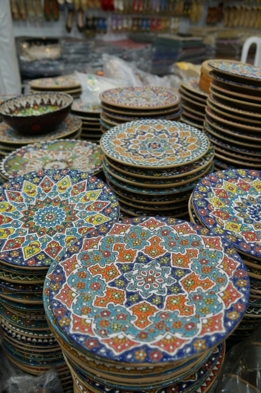 many colorful plates are piled next to each other