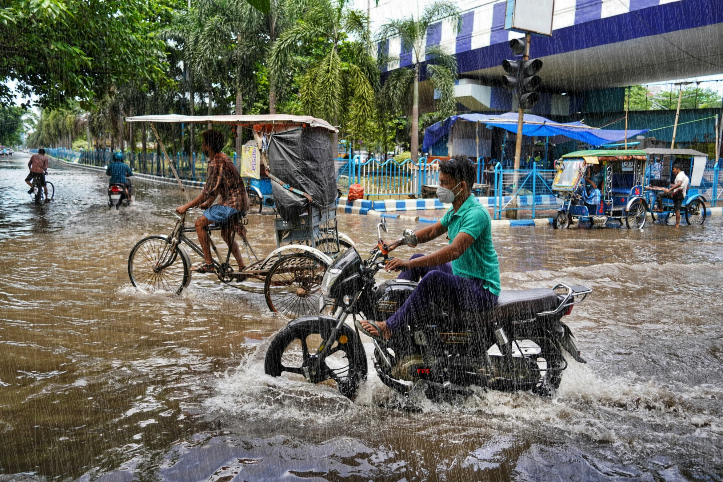 a man on a motorcycle in a flooded street