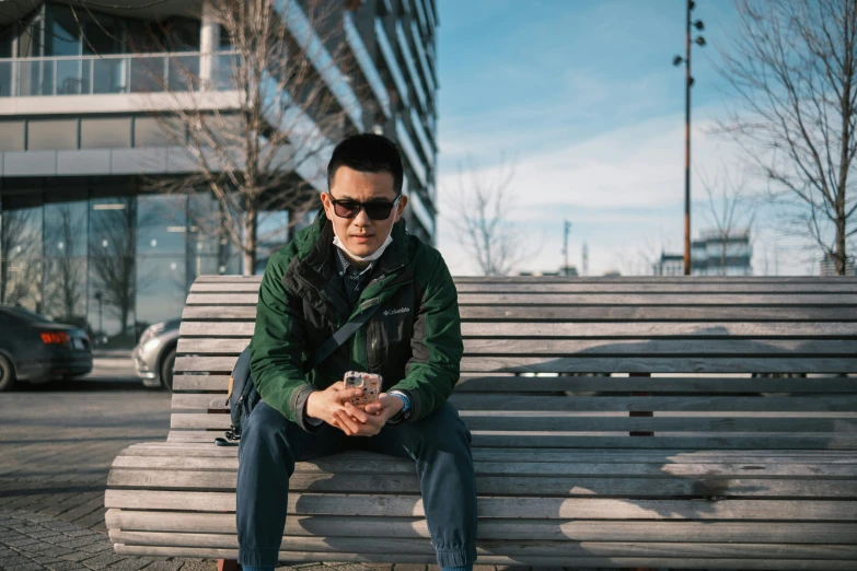 a man sitting on a park bench next to a building