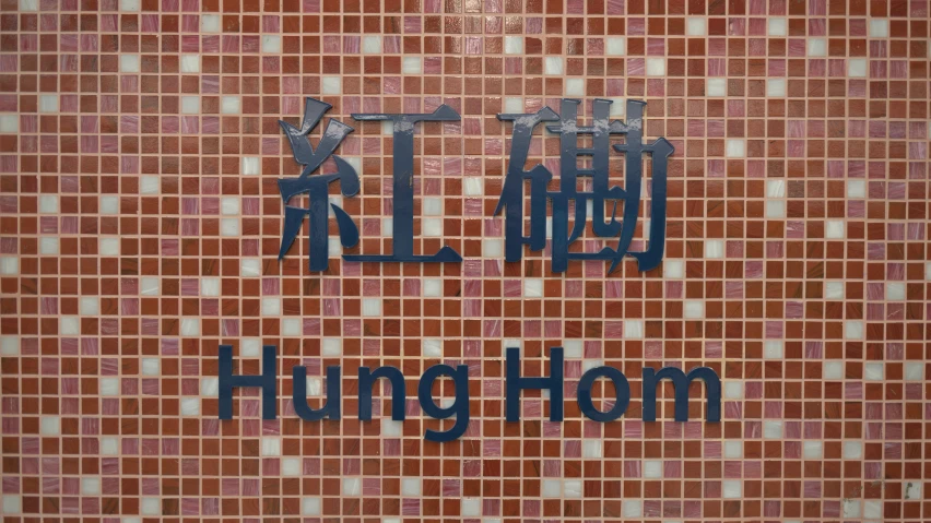 two signs with oriental and english writing on some brick