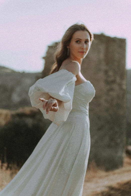 a woman posing in a long white dress