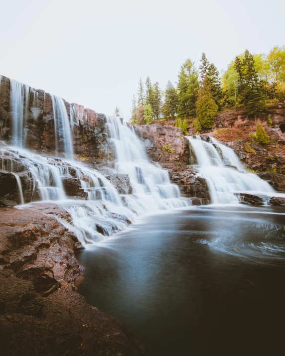 a long waterfall that is in the middle of a lake