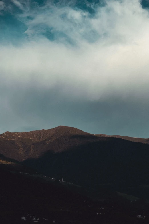 the mountains are covered with clouds in the sky