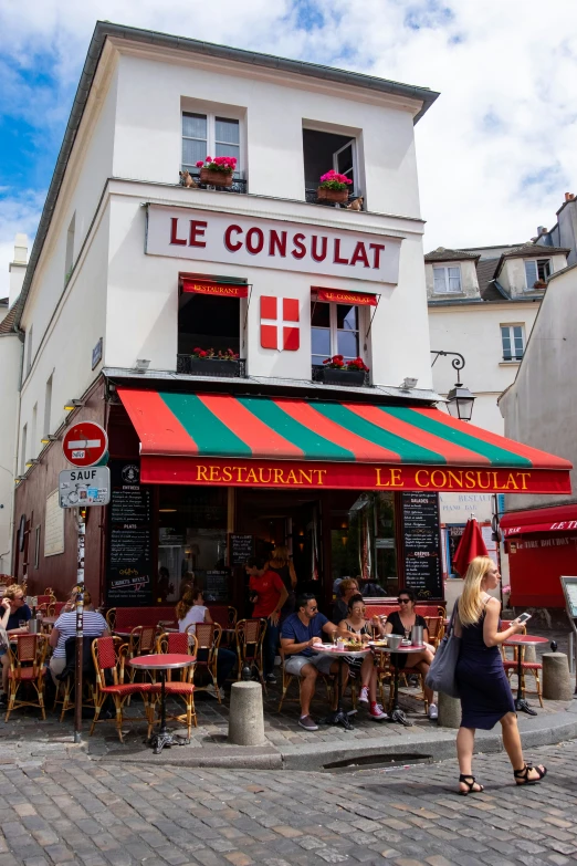 there are many people sitting outside of the restaurant