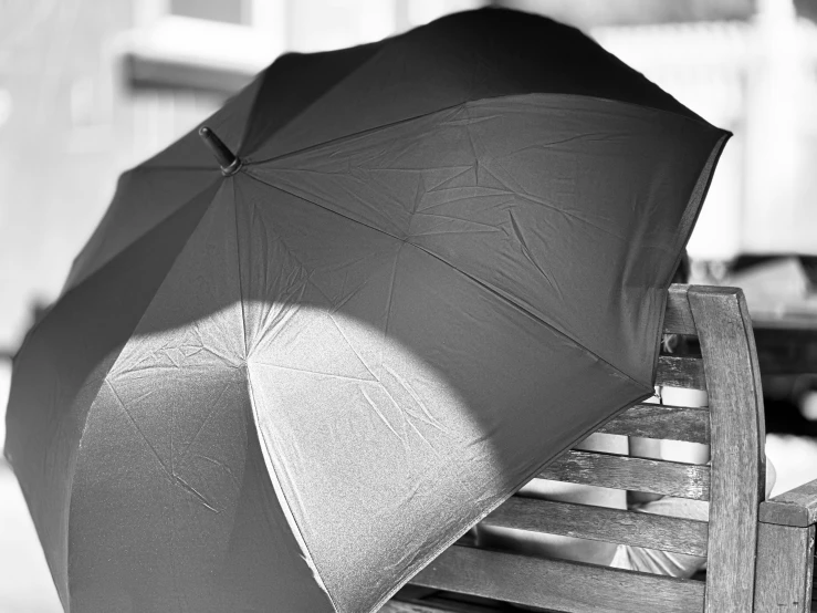 a person with an open umbrella and a chair