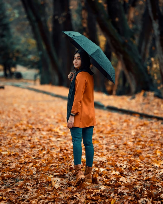 a woman walking with an umbrella in the park