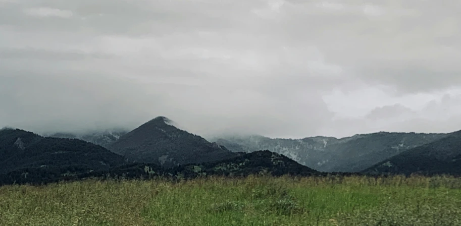 the clouds have gathered over the mountains in the distance