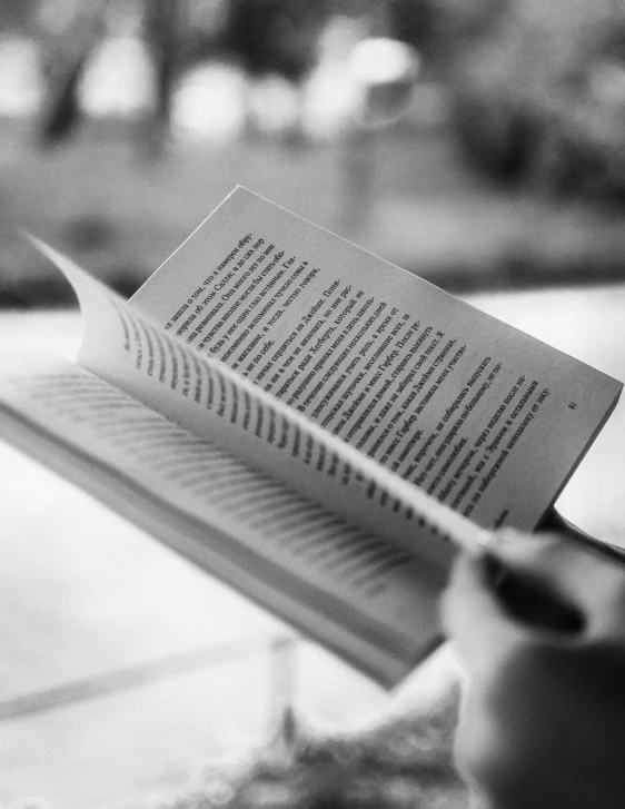 book and tea set on table with blurred view of street