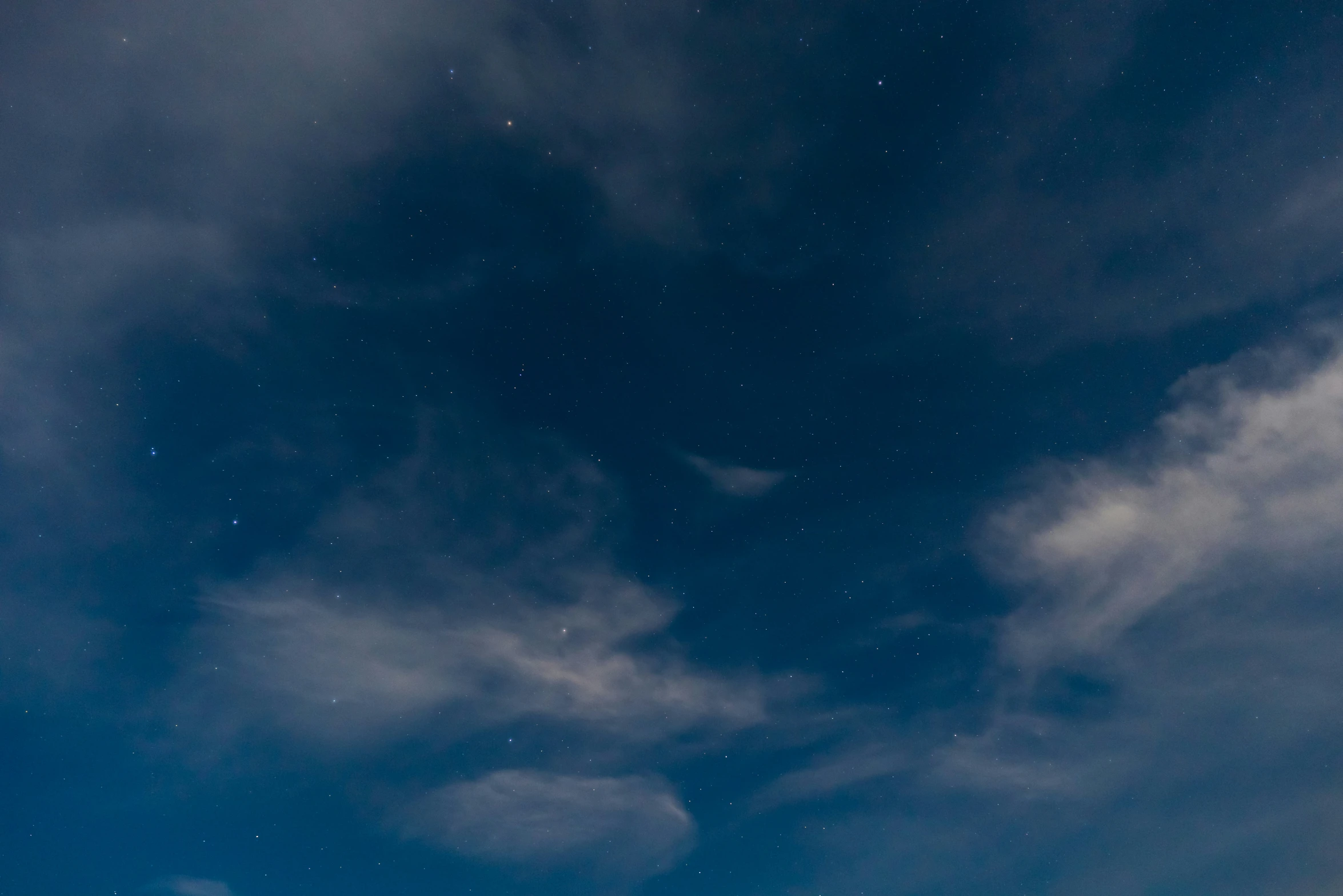 an image of some clouds and stars in the night sky