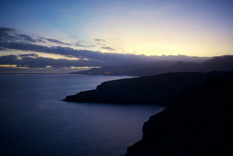 a body of water with some hills in the background