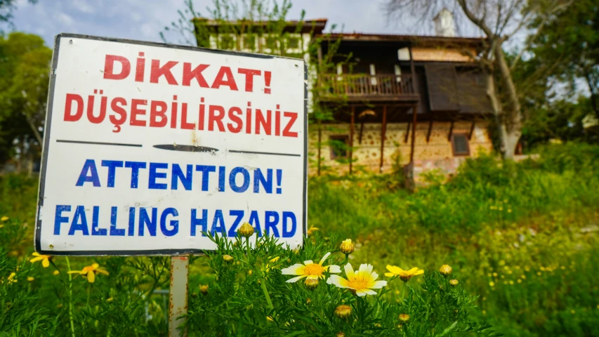 an attention sign is in front of an old house