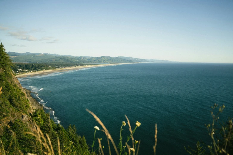 the beach has blue waters and green cliffs