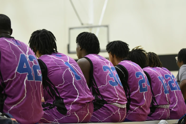 six basketball players are sitting down and facing the camera
