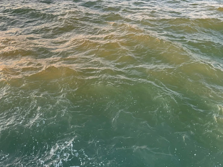 a person in a yellow life vest riding a surfboard