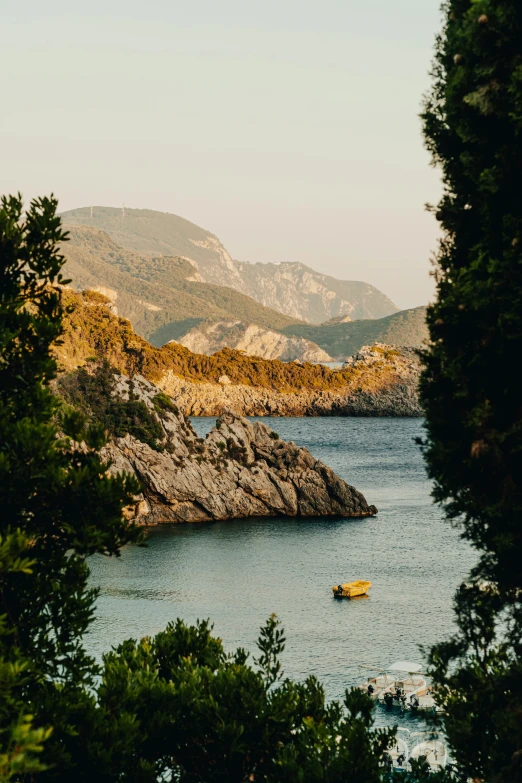 small boat on open water in front of large rocky landscape