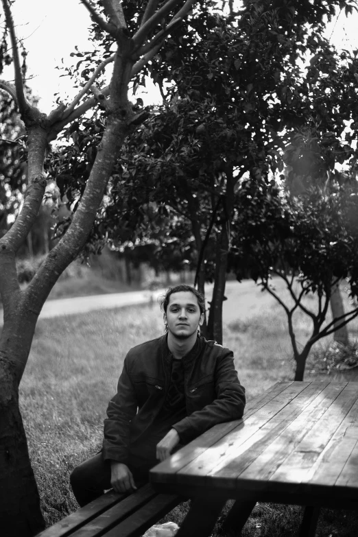 a man is sitting on a picnic table outside