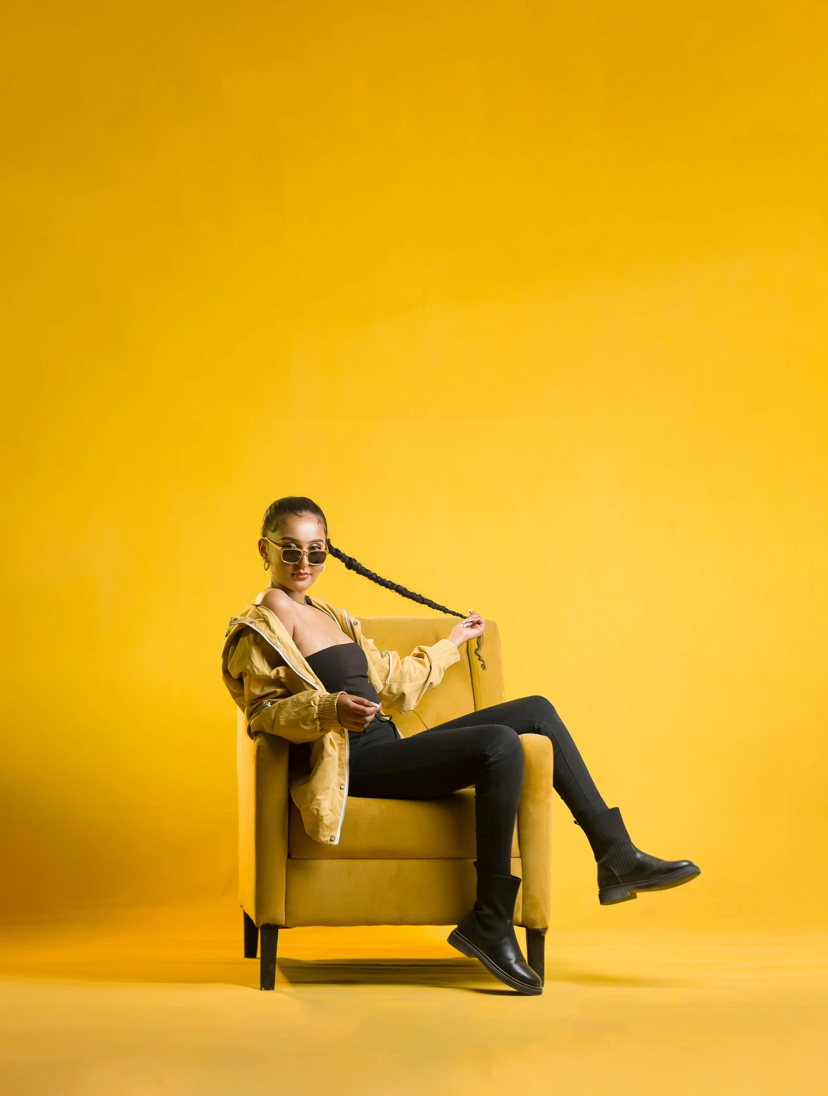 a woman sitting on a chair in front of a yellow background