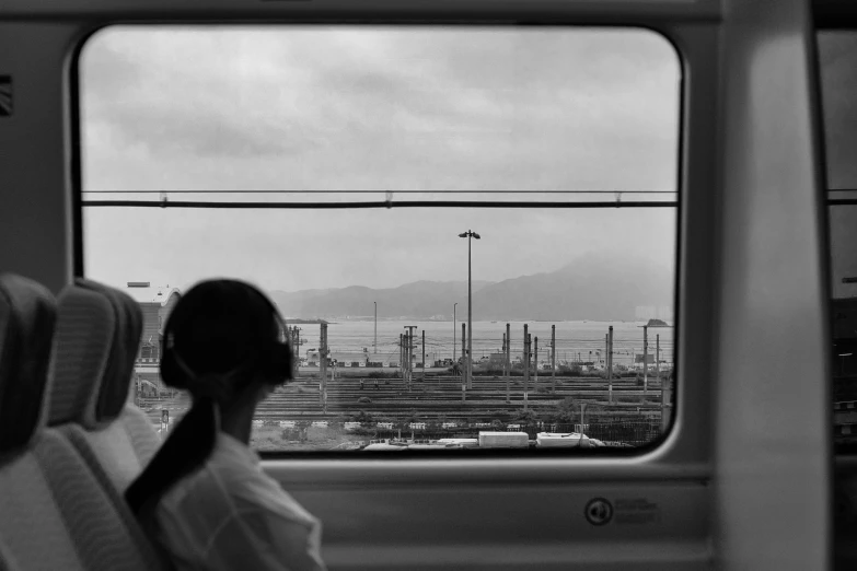 a woman sitting on a train looking at a port