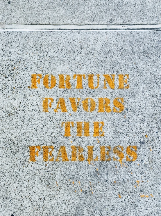 an orange sign is painted on a sidewalk