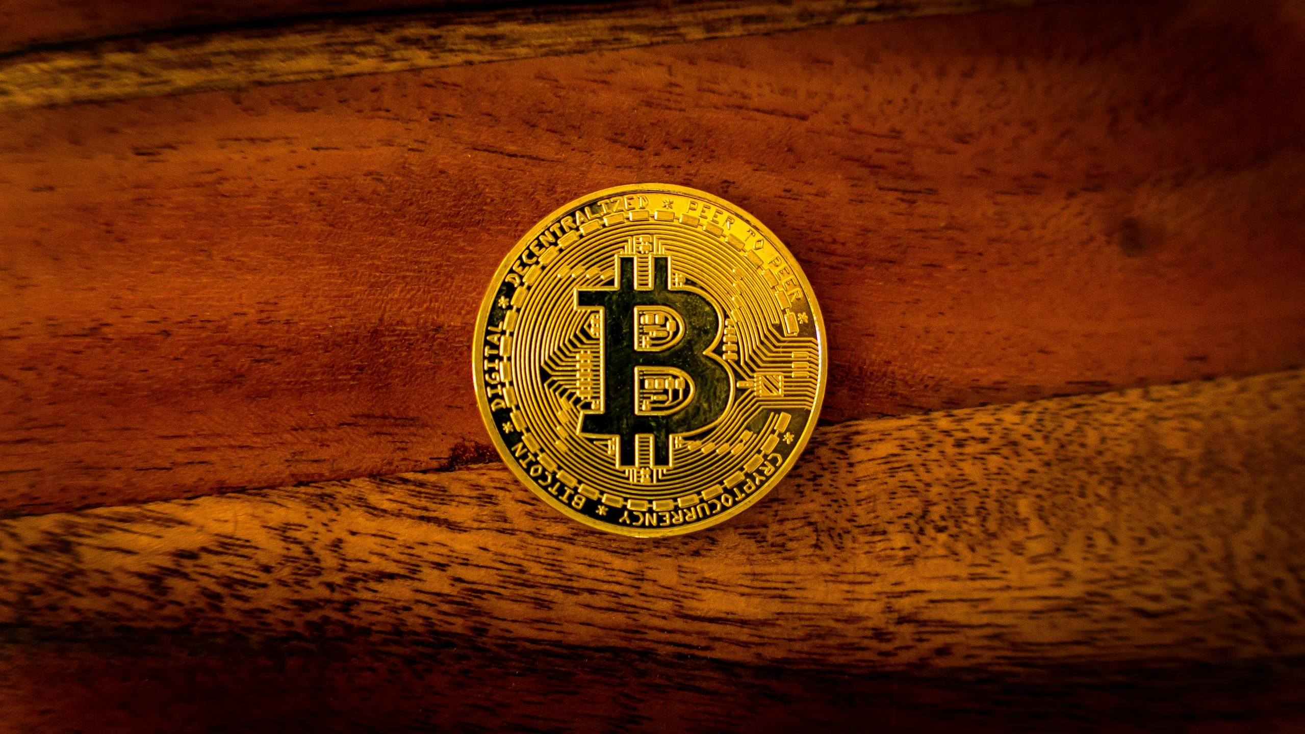 a bitcoin sitting on a wooden surface