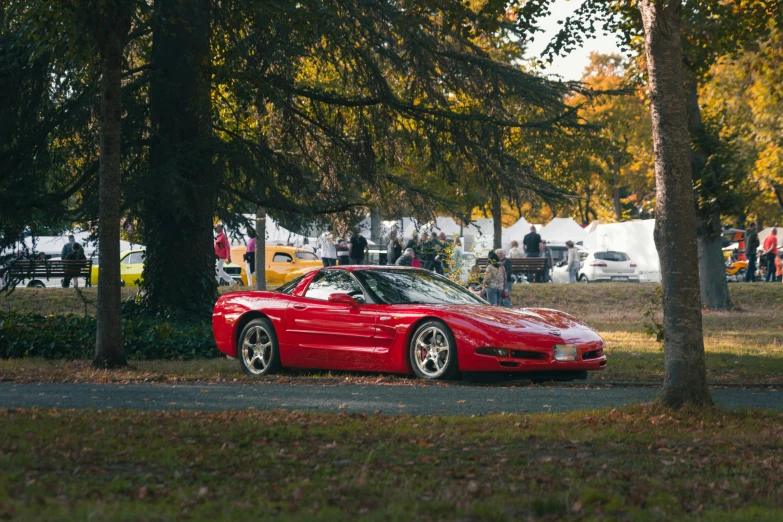 the red car is parked on the side of the road