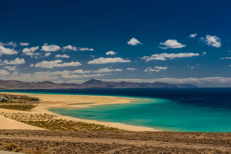 an empty beach sits at the edge of a large body of water