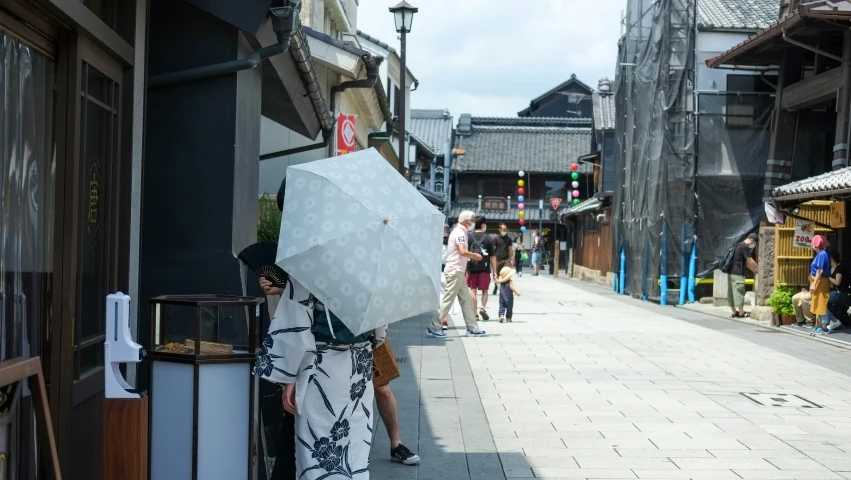 a woman in a black and white dress holding an umbrella