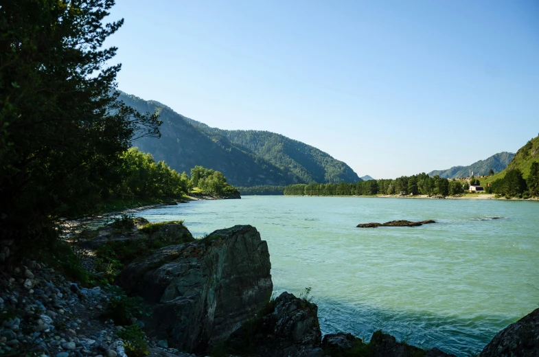 a river with mountain scenery and a green pond