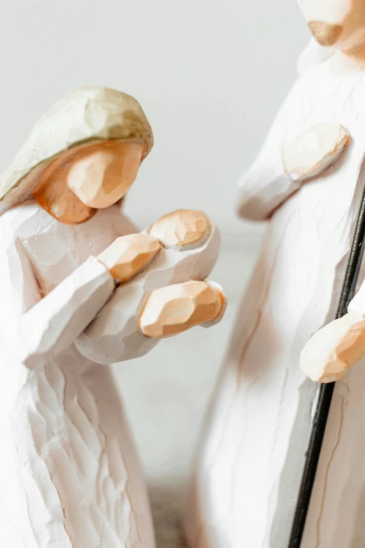 two ceramic angel figurines, one holding a spoon