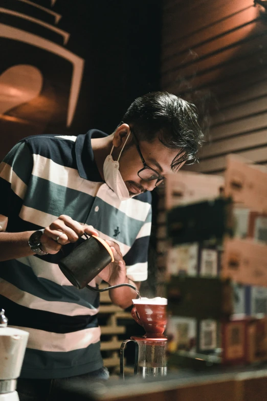 a man pouring soing into a cup near a bar