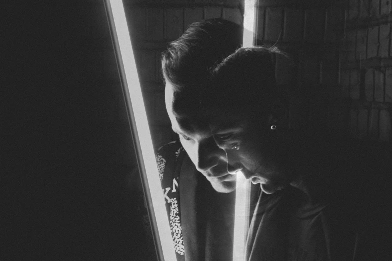 a man in a dark room holding onto a birthday cake