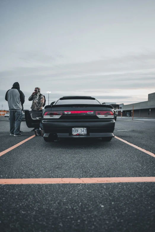 people look at the back end of a parked car