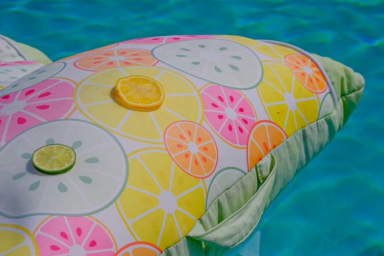 the pillow with an orange slice is in the water