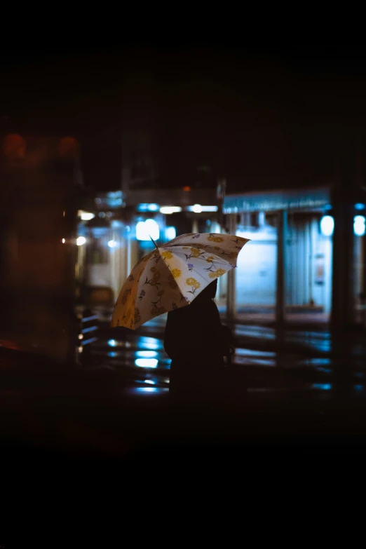 two people walking on the sidewalk, one holding an umbrella